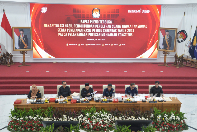 Ketua KPU Mochammad Afifuddin bersama anggota KPU memimpin rapat pleno rekapitulasi nasional Pemilu 2024 pascatindak lanjut putusan Mahkamah Konstitusi (MK) di Gedung KPU, Jakarta, Ahad (28/7/2024). Rapat pleno yang digelar pada hari batas akhir bagi KPU menggelar rekapitulasi nasional pascaputusan MK ini untuk mengubah sebagian Keputusan KPU Nomor 360 Tahun 2024 tentang Hasil Pemilu 2024 yang sebelumnya sudah disahkan pada 20 Maret 2024. Dalam kesempatan tersebut KPU juga mengumumkan bahwa Mochammad Afifuddin elah disepakati sebagai Ketua KPU RI secara definitif menggantikan Hasyim Asy