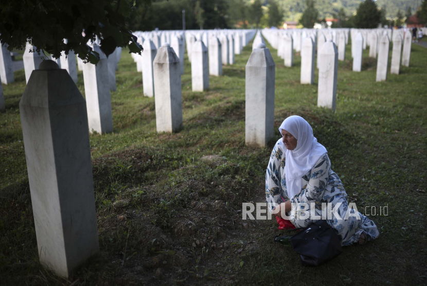  Seorang wanita muslim Bosnia berduka di sebuah makam di Pusat Peringatan di Potocari, Bosnia, Ahad, 10 Juli 2022. Ribuan orang berkumpul di kota Srebrenica di Bosnia timur untuk memperingati ulang tahun ke-27 pada hari Senin dari satu-satunya genosida yang diakui di Eropa sejak Perang Dunia II.
