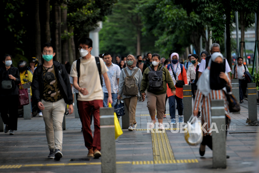 Pekerja berjalan di pedestrian kawasan perkantoran Sudirman, Jakarta, Selasa (2/5/2023). 