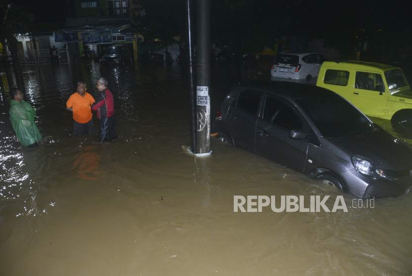 Tiga orang warga berbincang di tengah banjir yang melanda Perumnas Sudiang, Makassar, Sulawesi Selatan, Jumat (18/11/2022). Pemprov Sulsel menyalurkan sebanyak 1 ton beras korban banjir di Jeneponto.