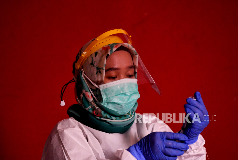 Petugas kesehatan bersiap menyuntikan vaksin COVID-19 kepada pedagang di Blok A Pasar Tanah Abang Jakarta, Kamis (25/2/2021). Kementerian Kesehatan memperpanjang periode vaksinasi COVID-19 pedagang di Pasar Tanah Abang hingga 2 Maret 2021 karena masih tingginya animo pedagang yang ingin divaksin mencapai 21.250 orang. 