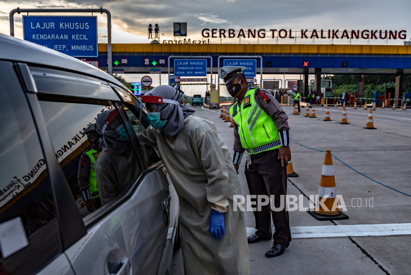 Petugas kesehatan memeriksa suhu pengendara roda empat saat penyekatan pemudik di Gerbang Tol Kalikangkung, Semarang, Jawa Tengah (26/5/2020). Sebanyak 1.085 kendaraan dari Jawa Tengah yang akan menuju ke Jakarta diminta putar balik. Ilustrasi. 