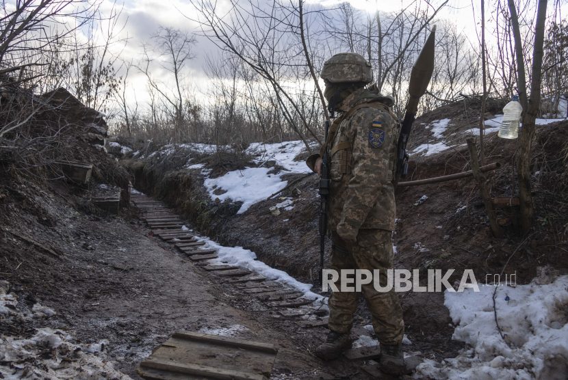 Seorang marinir Ukraina berjalan di parit di garis pemisah dari pemberontak pro-Rusia, wilayah Donetsk, Ukraina, Jumat, 7 Januari 2022. 
