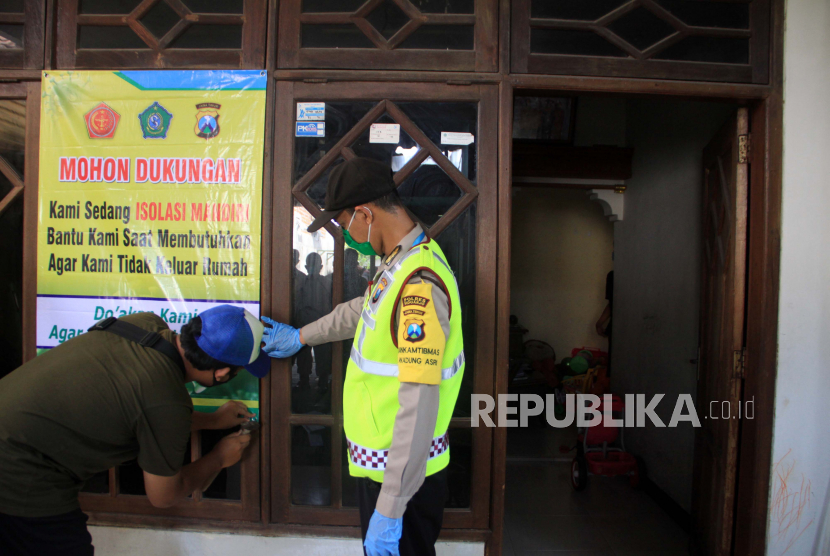 Warga dan polisi memasang poster berisi dukungan isolasi mandiri di rumah warga di Waru, Jawa Timur, Ahad (17/5/2020). Warga di kawasan tersebut melakukan isolasi mandiri karena salah satu warga di kampung tersebut dinyatakan positif Covid-19 (ilustrasi)
