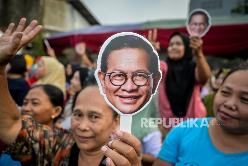 Warga membawa poster saat menyambut calon Gubernur DKI Jakarta nomor urut 3 Pramono Anung di Kampung Apung, Kapuk Teko, Jakarta, Jumat (25/10/2024).