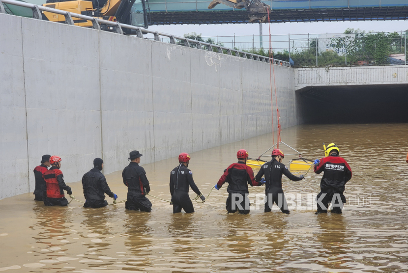 Tim penyelamat melakukan operasi pencarian di sepanjang jalan yang terendam banjir menuju terowongan bawah tanah di Cheongju, Korea Selatan, Ahad (16/7/2023).