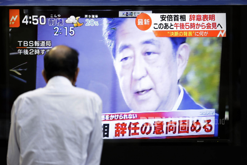  Seorang pria menonton berita di monitor yang ditempatkan di luar sebuah gedung di Tokyo pada hari Jumat (28/8/2020), menunjukkan laporan niat Perdana Menteri Jepang Shinzo Abe untuk mengundurkan diri karena kesehatannya yang menurun. 