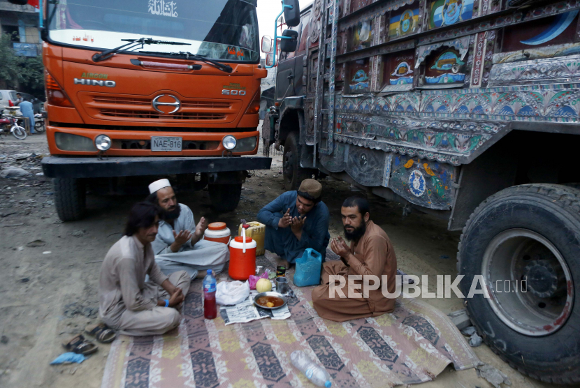 Pengemudi truk berdoa sebelum berbuka puasa selama bulan suci Ramadhan, di Lahore, Pakistan, Kamis, 15 April 2021.