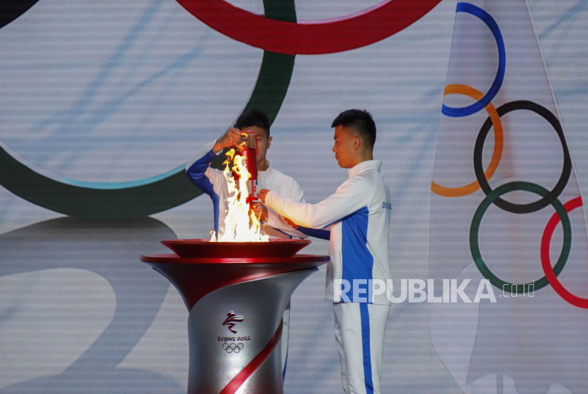 Peserta memindahkan nyala api Olimpiade dari kuali pada upacara penyambutan nyala api Olimpiade Musim Dingin Beijing 2022 di Beijing, Tiongkok, 20 Oktober 2021. 