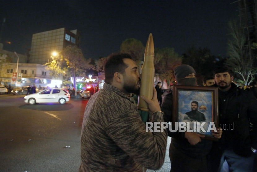 Pria mencium roket tiruan saat unjuk rasa anti-Israel setelah Iran melancarkan serangan pesawat tak berawak terhadap Israel di Lapangan Palestina di Teheran, Iran, dini hari (14/4/2024).
