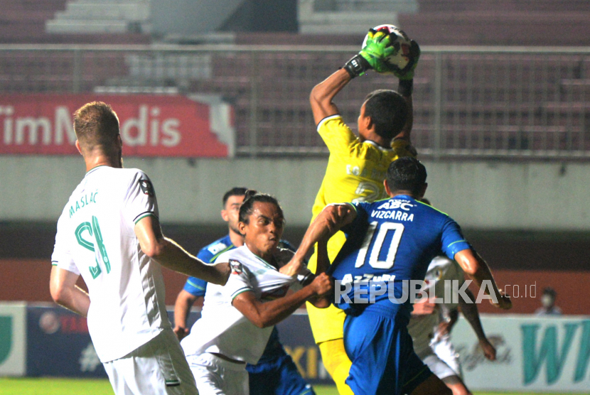 Kiper PSS Ega Rizky menangkap bola crossing Persib pada pertandingan Semifinal Pertama Piala Menpora 2021 di Stadion Maguwoharjo, Sleman, Yogyakarta, Jumat (16/4) malam. Pada pertandingan Semifinal pertama ini Persib berhasil mengalahkan PSS 2-1.