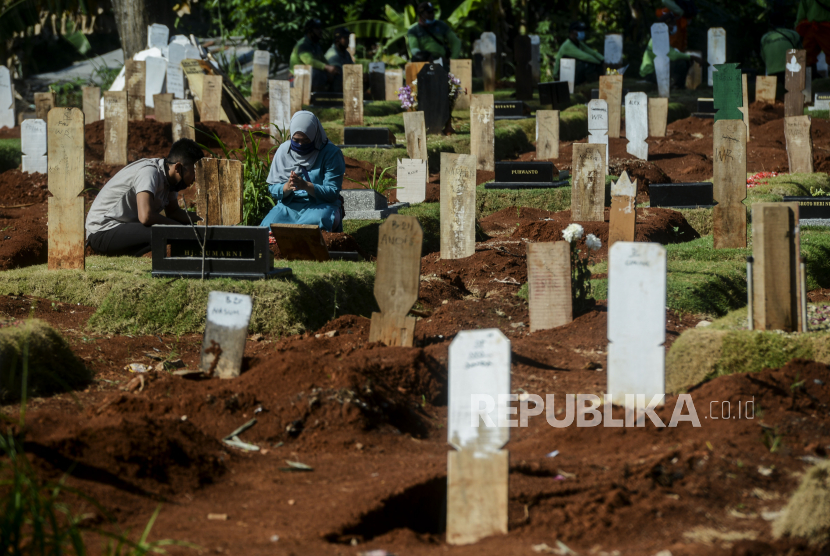 Warga melakukan ziarah kubur di area pemakaman korban COVID-19 