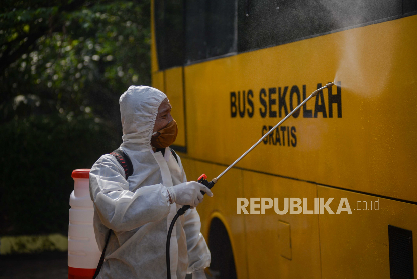 DKI Operasikan Bus Sekolah Selama Uji Belajar Tatap Muka. Petugas menyemprotkan cairan disinfektan ke bus sekolah.