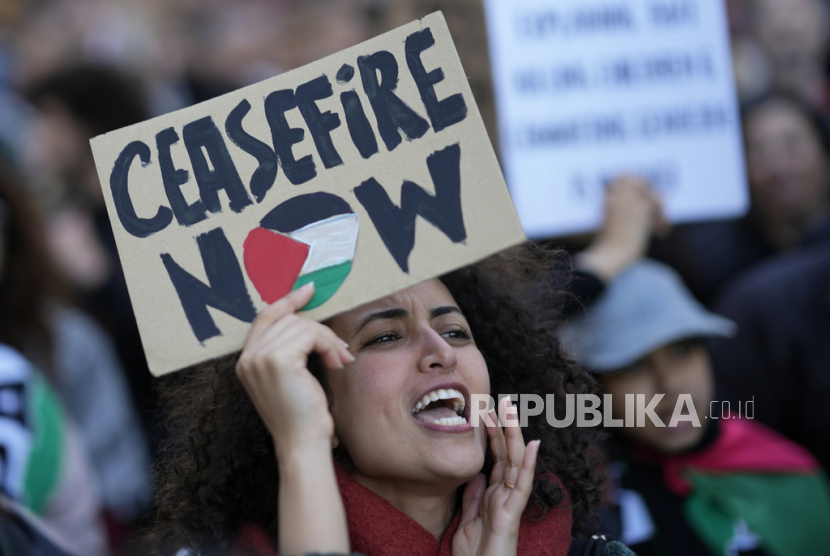 Seorang wanita memegang poster meneriakkan slogan-slogan saat demonstrasi mendukung rakyat Palestina dan menuntut gencatan senjata di Gaza, di Lisbon, Sabtu, 10 Februari 2024.