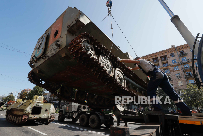 Pekerja angkatan darat dan kota menyiapkan kendaraan militer lapis baja Rusia yang rusak yang disita oleh tentara Ukraina di tengah invasi Rusia, di sepanjang Jalan Khreshchatyk di Kyiv (Kiev), Ukraina, (22/8/2023).