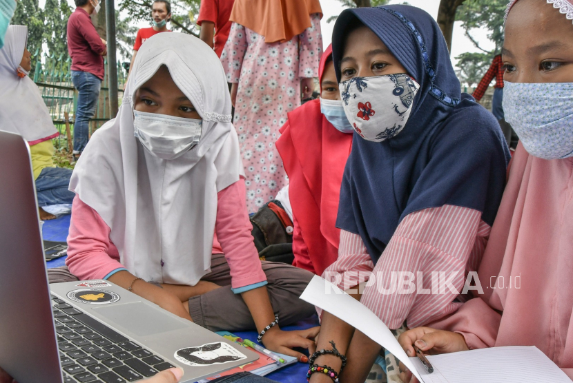 Sejumlah murid Sekolah Dasar (SD) mengamati video pembelajaran di Taman Katar Pusaka, Bekasi, Jawa Barat, Sabtu (6/3/2021). Kegiatan tersebut digelar untuk membantu anak-anak yang belum memahami materi pembelajaran dari sekolah yang dilakukan secara daring karena pandemi COVID-19. ANTARA FOTO/Fakhri Hermansyah/wsj.