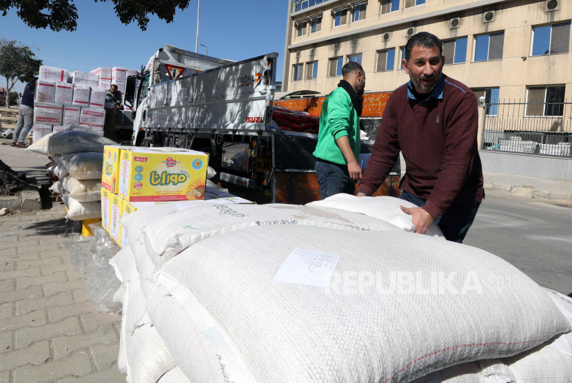 Para pekerja mengisi karung-karung berisi makanan saat organisasi non-pemerintah Bank Makanan Mesir menyiapkan sumbangan makanan untuk warga Palestina di Jalur Gaza, di gudang di New Kairo, MesIir, 