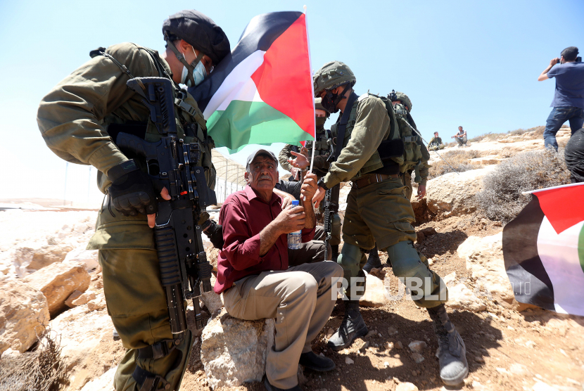Tentara Israel berdebat dengan warga Palestina selama protes di Tepi Barat, di desa Yatta, dekat Hebron, 21 Agustus 2020. Warga Palestina memprotes perjanjian perdamaian untuk membangun hubungan diplomatik antara Israel dan Uni Emirat Arab.