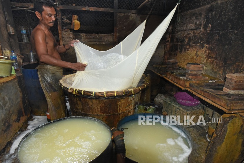 Perajin tahu menyaring sari kedelai yang sudah digiling di sentra produksi Konperasi Tahu Tempe di Pejaten, Serang, Banten, Selasa (5/1/2021). 