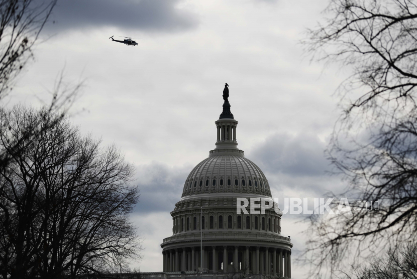  Sebuah helikopter polisi terbang di atas Capitol saat keamanan ditingkatkan menjelang upacara pelantikan Presiden terpilih Joe Biden Senin, 18 Januari 2021, di Washington.