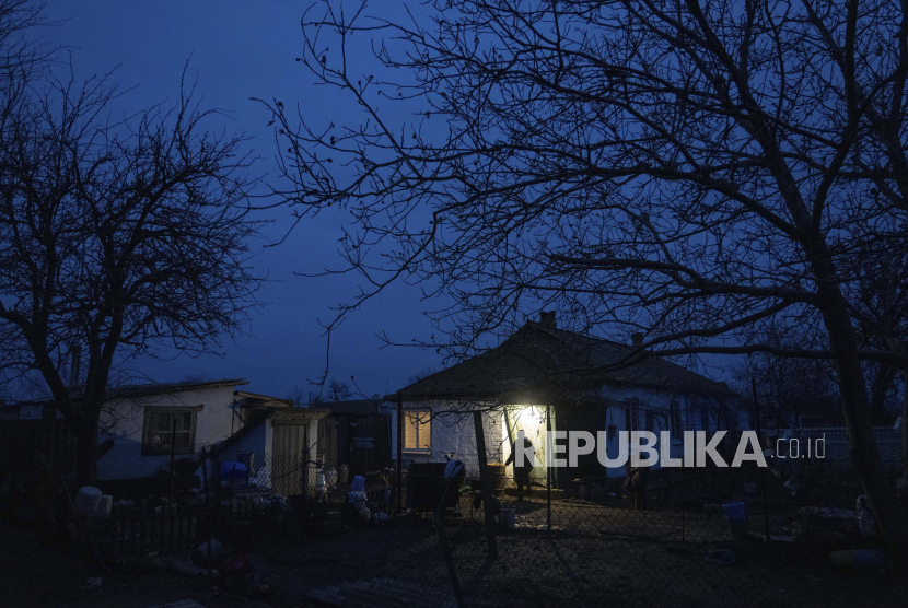 Warga berjalan di halaman depan rumahnya di desa Vysoke, wilayah Kherson, Ukraina, Sabtu, 3 Desember 2022. Pemerintah Rusia mengatakan, mereka tidak akan melepaskan kembali empat wilayah Ukraina yang sudah mereka aneksasi, yakni Luhansk, Donetsk, Zaporizhzhia, dan Kherson. 
