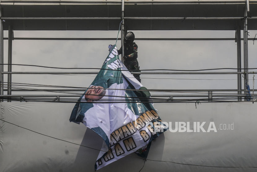 Anggota TNI saat menertibkan spanduk Habib Rizieq Shihab di kawasan Petamburan, Jakarta, Jumat (20/11). Upaya menurunkan spanduk atau baliho Habib Rizieq juga dilakukan di Kota Bekasi.