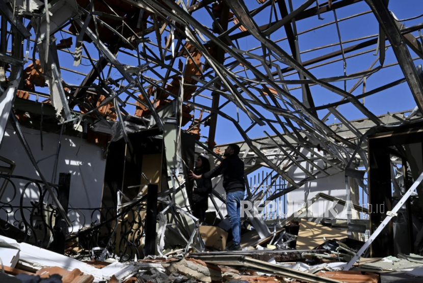  Para pekerja memeriksa kantor mereka di gudang yang hancur, satu hari setelah serangan udara Israel di kawasan industri, di kota pesisir selatan Ghaziyeh, Lebanon, (20/2/2024). 