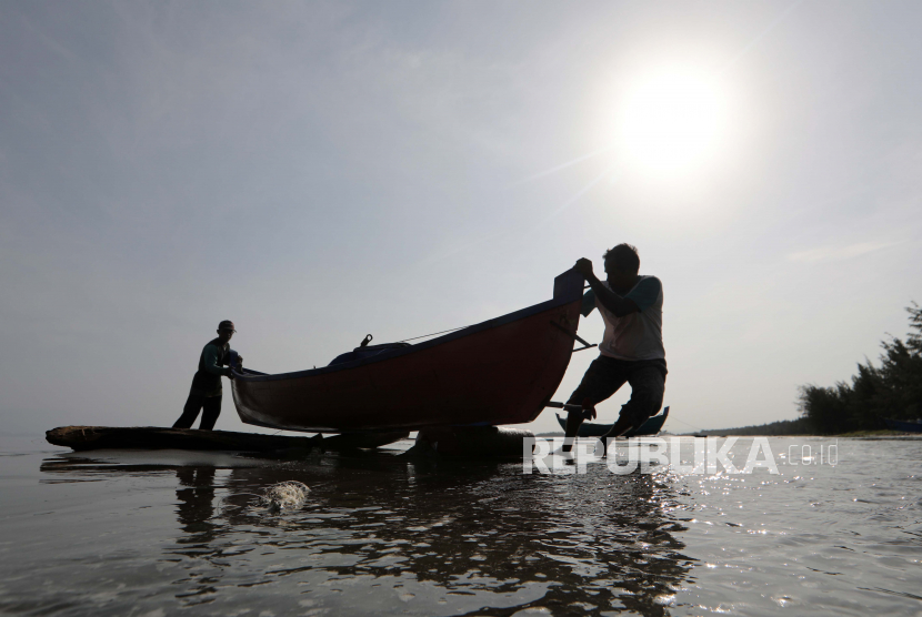  Nelayan mendorong perahu mereka ke darat setelah kembali dari melaut, di Banda Aceh, Kamis (12/5/2022).