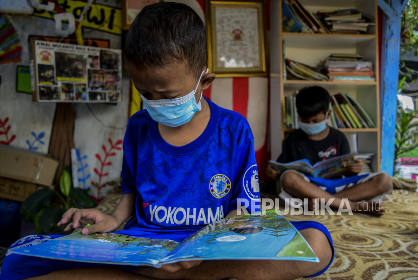 Anak-anak saat membaca buku di Bale Buku, Gang Dendrit, Cakung, Jakarta, Jumat (4/6). Bale Buku yang memanfaatkan tempat pos ronda itu menjadi sarana edukasi, bermain dan belajar, yang bertujuan untuk meningkatkan literasi anak-anak di lingkungan Gang Dendrit.