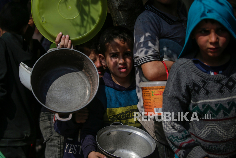 Anak-anak pengungsi Palestina antre untuk menerima makanan yang disediakan oleh relawan di kota Deir Al Balah, Jalur Gaza Selatan, Sabtu (24/2/2024). Sebanyak 1,9 juta orang telah mengungsi di Gaza akibat konflik berkepanjangan. Badan Bantuan dan Pekerjaan PBB untuk Pengungsi Palestina (UNRWA) menyatakan sebagian besar warga sipil di Gaza sangat membutuhkan bantuan kemanusiaan.