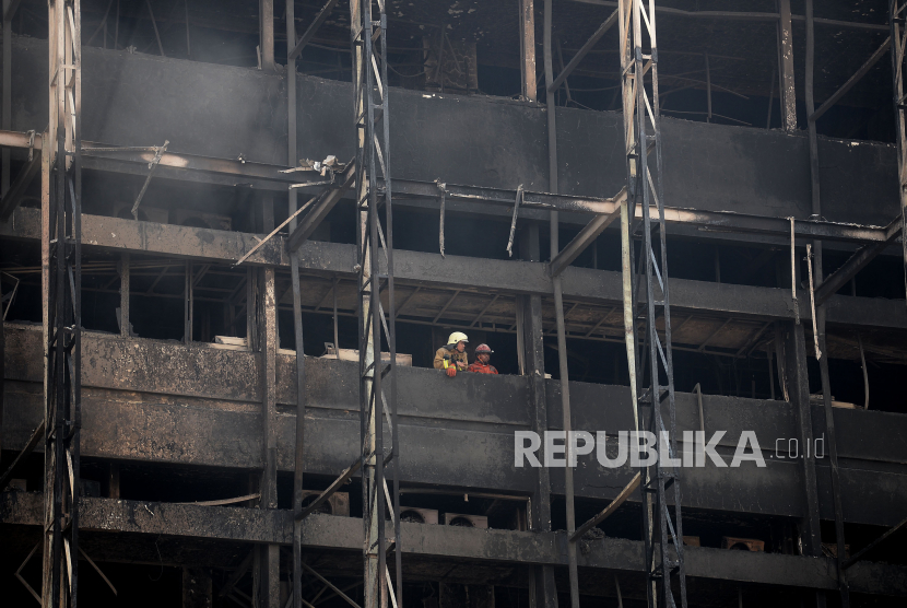 Petugas pemadam kebakaran beraktivitas di salah satu lantai gedung Kejaksaan Agung yang terbakar di Jakarta, Ahad (23/8). Kebakaran tersebut berawal sejak Sabtu (22/8) malam dan api diduga sementara berasal dari lantai enam yang merupakan bagian kepegawaian.Prayogi/Republika