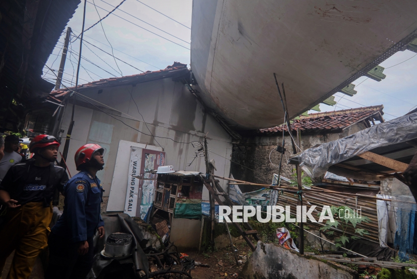 Petugas melihat kondisi rumah yang tertimpa sayap pesawat akibat bencana angin puting beliung di Desa Pondok Udik, Kemang, Kabupaten Bogor, Jawa Barat, Senin (29/12/2025). Peristiwa angin puting beliung mengakibatkan bagian pesawat dari gudang pesawat bekas terhempas menimpa rumah warga dan menurut data dari Pemerintah Desa setempat sementara 30 rumah tercatat rusak serta tidak ada korban jiwa dari kejadian tersebut. 
