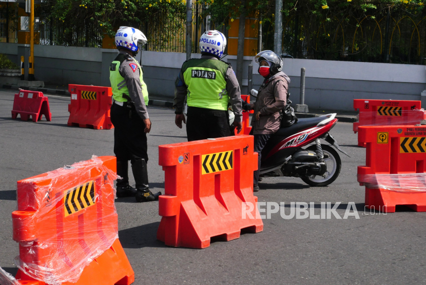 Pengendara bertanya kepada petugas saat penyekatan di Jalan Adisucipto, Yogyakarta, Rabu (7/7). Penyekatan dilakukan untuk proses penyemprotan disinfektan oleh petugas. Penyemprotan ini untuk mengurangi  penyebaran Covid-19.
