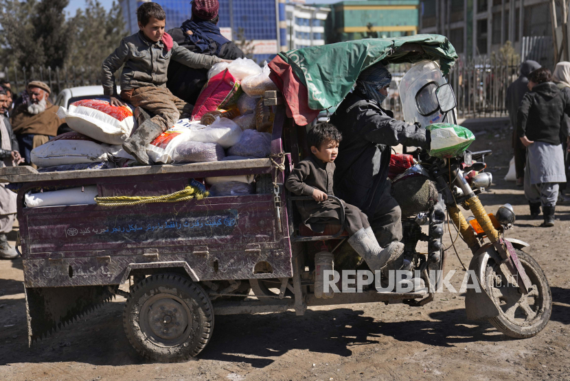  Seorang pria Afghanistan dengan anak-anaknya naik kendaraan roda tiga setelah mereka menerima pasokan makanan, selama distribusi bantuan kemanusiaan untuk keluarga yang membutuhkan, di Kabul, Afghanistan, Rabu, 16 Februari 2022. Perserikatan Bangsa-Bangsa (PBB) mengatakan, Afghanistan membutuhkan bantuan senilai 4,4 miliar dolar AS untuk menghindari krisis pangan.