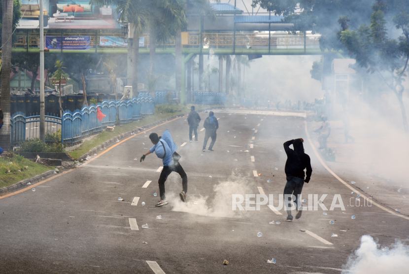Sejumlah mahasiswa melempari petugas polisi saat unjuk rasa menolak UU Cipta Kerja di Kota Pekanbaru, Riau, Kamis (8/10/2020). 