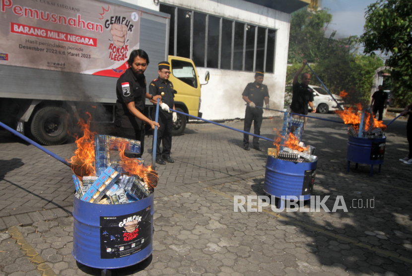 Petugas memusnahkan barang bukti rokok ilegal di halaman Kantor Pengawasan dan Pelayanan Bea dan Cukai (KPPBC) Tipe Madya Pabean B di Juanda, Sidoarjo, Jawa Timur, Jumat (11/8/2023).