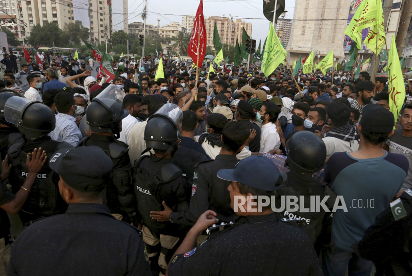  Petugas polisi Pakistan memblokir Muslim Syiah yang berbaris menuju Konsulat Prancis selama unjuk rasa melawan Presiden Prancis Emmanuel Macron dan penerbitan ulang karikatur Nabi Muhammad yang mereka anggap menghujat, di Karachi, Pakistan, Minggu, 1 November 2020.