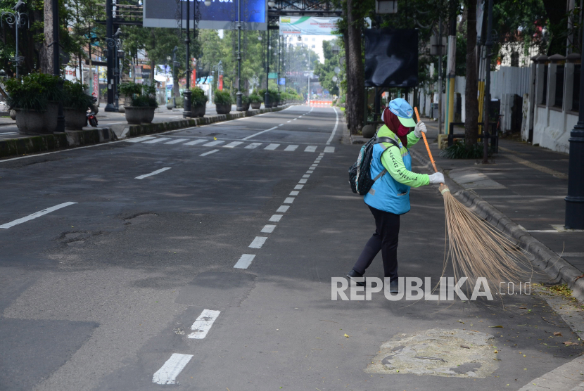 Petugas kebersihan menyapu Jalan Ir H Djuanda, Kota Bandung, saat diberlakukannya penutupan jalan, Rabu (15/4). Kota Bandung berencana akan melakukan Pembatasan Sosial Berskala Besar (PSBB) pada tanggal 22 April 2020 selama 14 hari