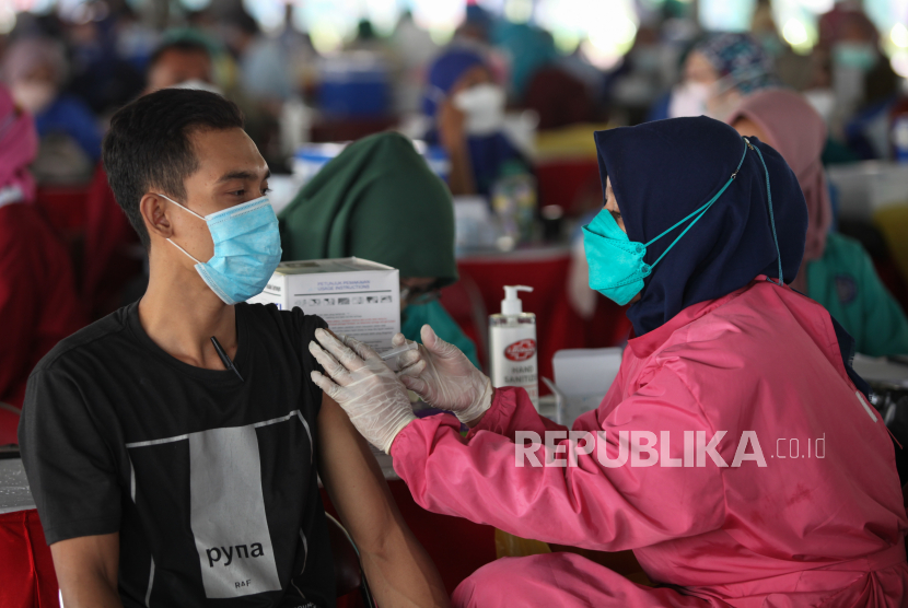 Petugas menyuntikkan vaksin COVID-19 kepada warga di Lapangan Thor, Surabaya, Jawa Timur, Kamis (30/9/2021). Vaksinasi COVID-19 yang diinisiasi Koarmada II dalam rangka percepatan penanganan COVID-19 dan pemulihan ekonomi nasional tersebut menyiapkan 30.000 dosis vaksin COVID-19 setiap harinya dan berlangsung selama dua hari. 