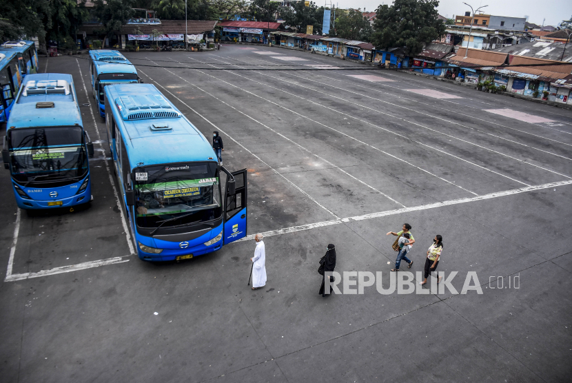 Warga berjalan menuju bus Damri yang terparkir di Terminal Cicaheum, Kota Bandung, Jumat (7/5). Damri hingga semester I 2021 masih mencatat penurunan jumlah penumpang. 