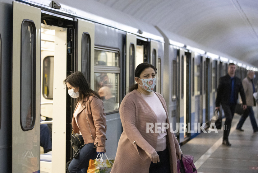 Orang-orang memakai masker dan sarung tangan untuk melindungi dari virus corona di kereta bawah tanah di Moskow, Rusia, Selasa (12/5). Rusia melaporkan 10.598 kasus baru kasus Covid-19 selama 24 jam terakhir.