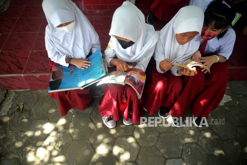 Siswa membaca buku bacaan dari mobil Perpustakaan Keliling Kota Yogyakarta saat kunjungan ke SDN 2 Keputran, Yogyakarta, Senin (15/5/2023). Setiap dua pekan perpustakaan keliling akan berkunjung ke sekolah dasar. Program ini untuk meningkatkan minat dan kebiasaan membaca siswa sekolah. Tidak hanya itu, petugas juga membantu dan mendampingi siswa-siswa yang membaca buku.