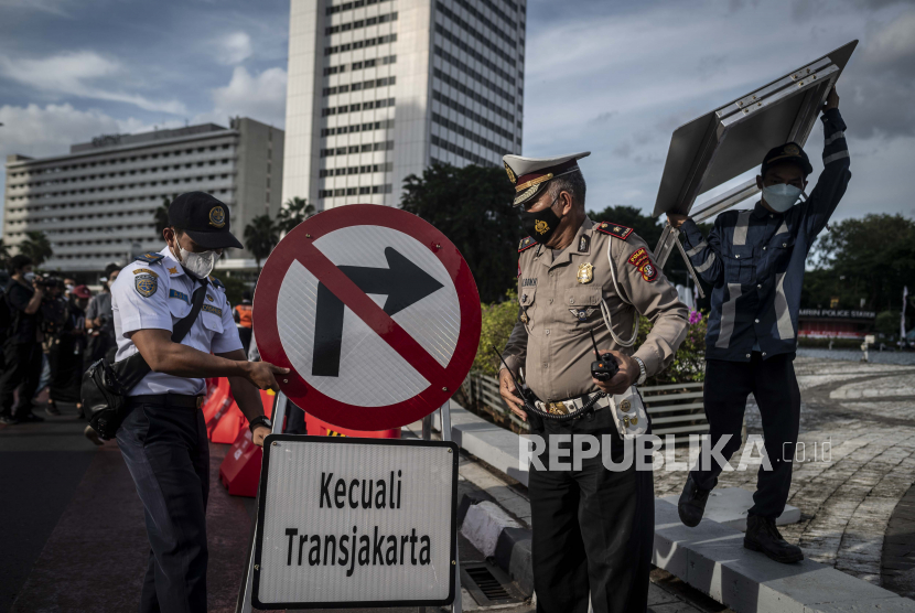 Petugas Dishub DKI Jakarta bersama Polisi Lalu Lintas memasang rambu-rambu lalu lintas saat penerapan uji coba rekayasa lalu lintas di kawasan Bundaran Hotel Indonesia, Jakarta, Senin (4/7/2022). Dishub DKI Jakarta bersama Ditlantas Polda Metro Jaya menerapkan uji coba rekayasa lalu lintas di kawasan tersebut mulai 4-10 Juli 2022 pukul 16.00-21.00 WIB untuk mengurai kepadatan lalu lintas. 