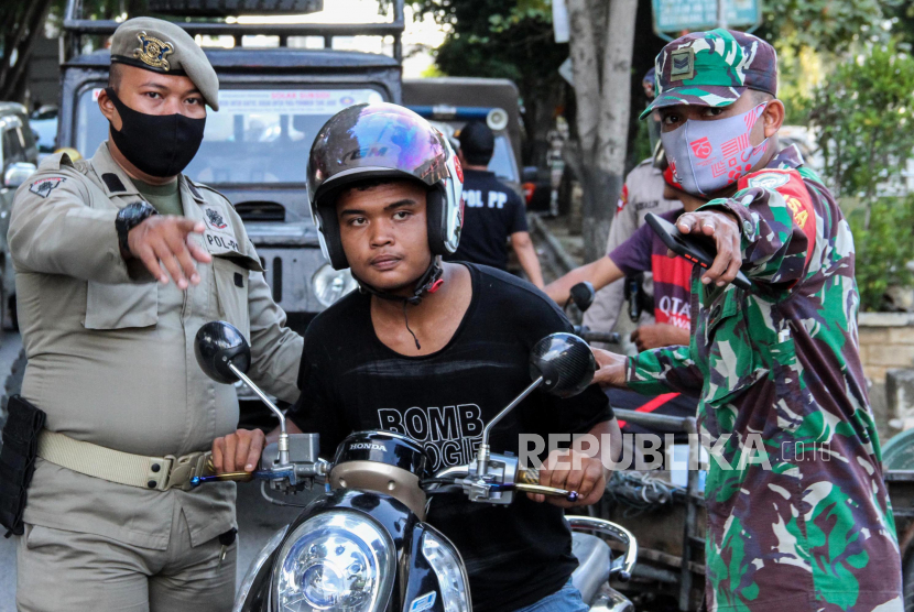 Satgas gabungan menjaring warga tidak memakai masker saat digelar Operasi Yustisi Protokol COVID-19 di Pusat Kota Lhokseumawe, Aceh, Rabu (16/9/2020). Operasi itu menerapkan sanksi sosial cabut rumput dan membersihkan sampah bagi warga tidak bermasker untuk meningkatkan disiplin dan kepatuhan terhadap protokol kesehatan sebagai upaya pencegahan dan pengendalian penyebaran COVID-19 yang terus meningkat di Aceh. 