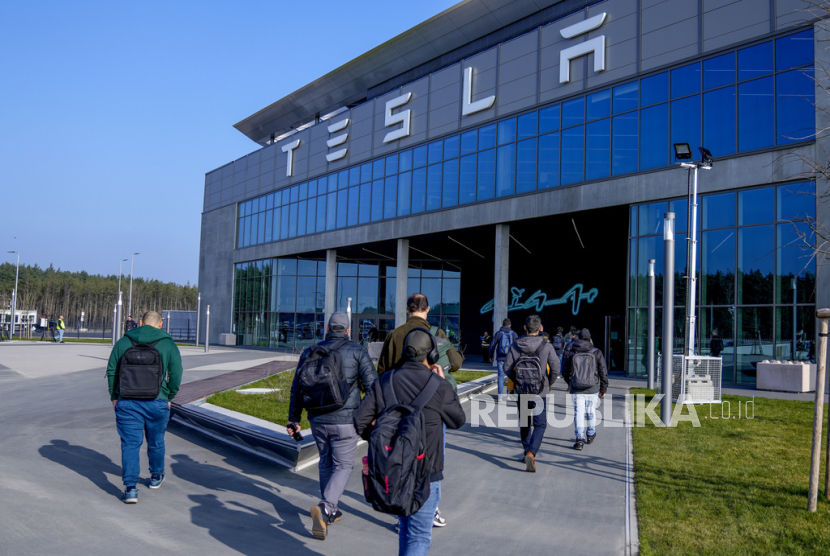 Orang-orang berjalan di depan Tesla Gigafactory untuk membeli mobil listrik di Gruenheide dekat Berlin, Jerman.