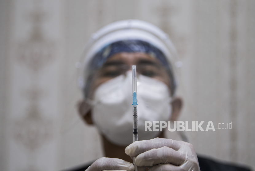 Vaksinator memperlancar cairan vaksin pada alat suntik sebelum vaksinasi Ccvid-19 dilakukan (ilustrasi) 