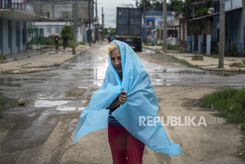 Seorang warga menggunakan plastik sebagai pelindung dari hujan di Batabano, Kuba, Senin, 26 September 2022. Badai Ian semakin kuat saat mendekati ujung barat Kuba di jalur untuk menghantam pantai barat Florida sebagai badai besar. awal Rabu.