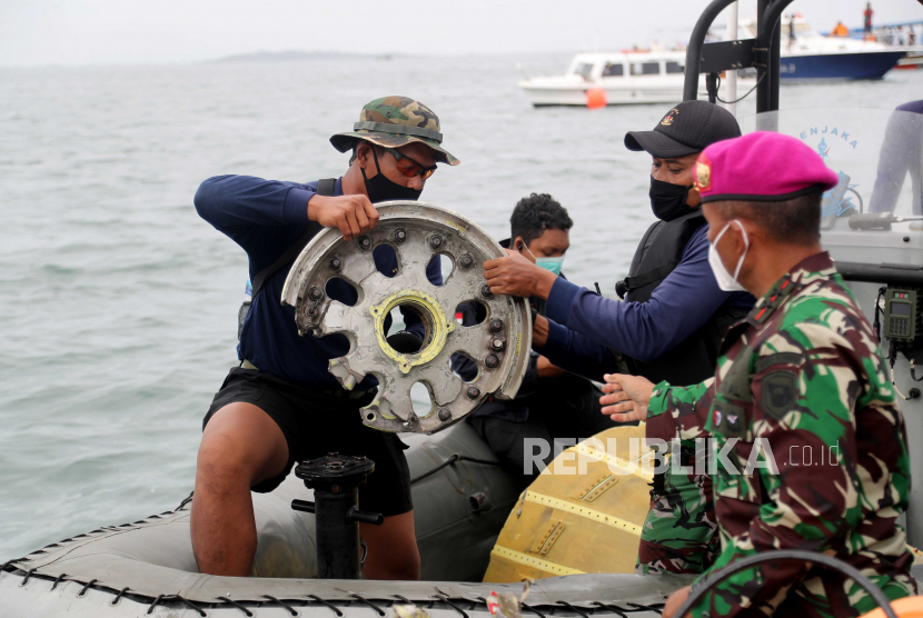 Dankormar Mayjen Suhartono (kanan) bersama personel Marinir mengangkat temuan puing pesawat Sriwijaya Air SJ182 di perairan Kepulauan Seribu, DKI Jakarta, Ahad (10/1). 