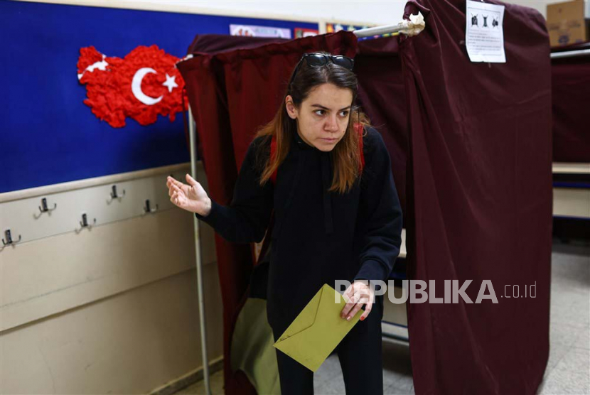 Seorang wanita memberikan suaranya saat dia memberikan suara di TPS di Ankara, Turki, Ahad, (28/5/2023).