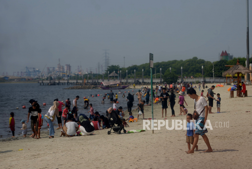 Pengunjung memadati kawasan Pantai Ancol di Taman Impian Jaya Ancol, Jakarta. Area pantai di Ancol menjadi area yang selalu dipadati pengunjung saat liburan.